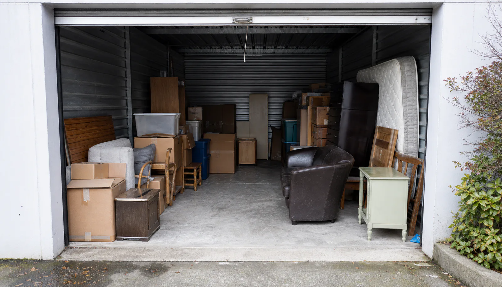 Boxes and unwanted furniture inside a partially filled storage unit